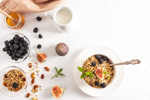 top view of the bowl with a healthy healthy breakfast of granola or muesli and ingredients for its preparation. white background. Detox